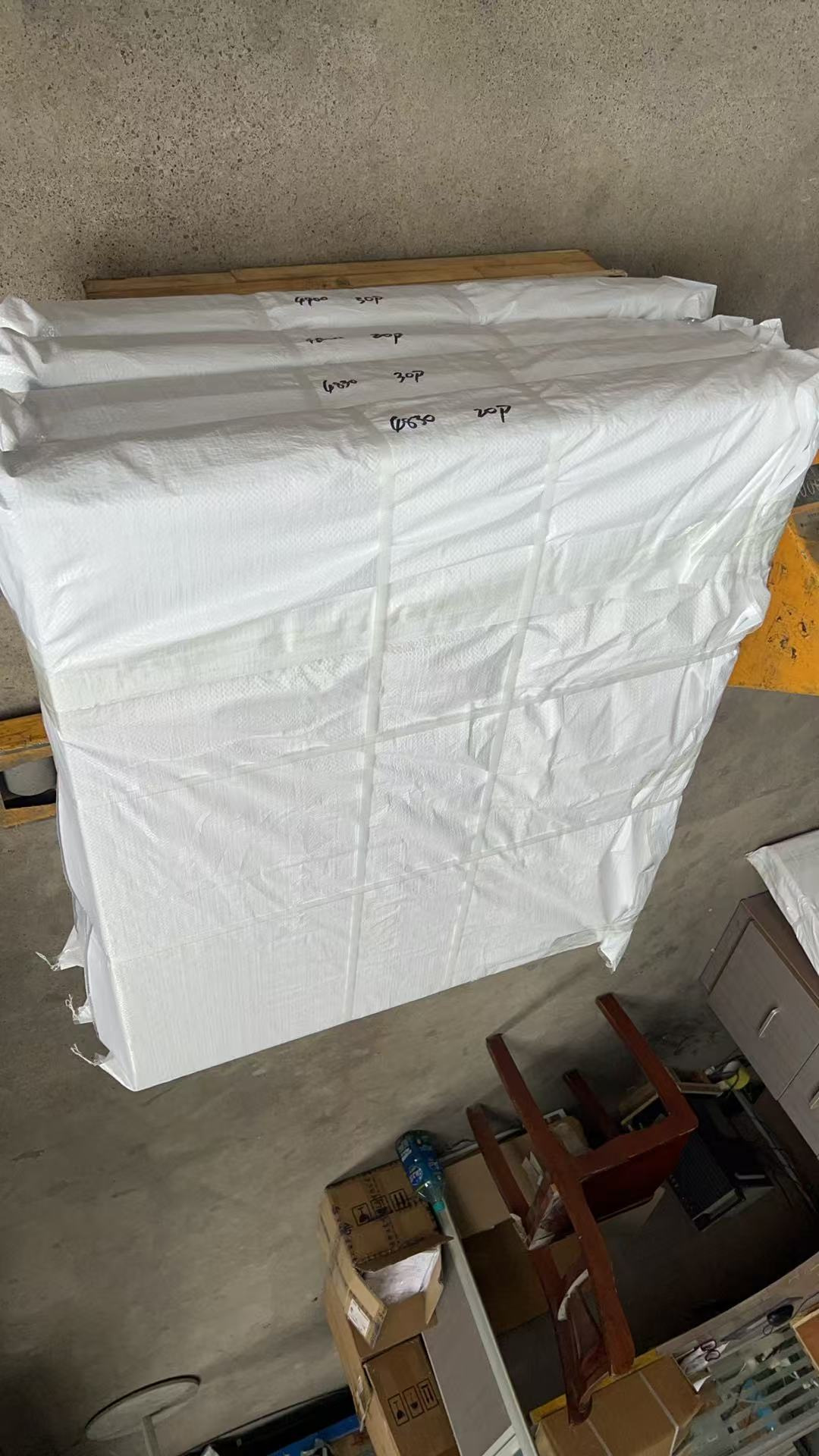 Packed goods on pallets staged in an aisle, marked by batch and ready for dispatch